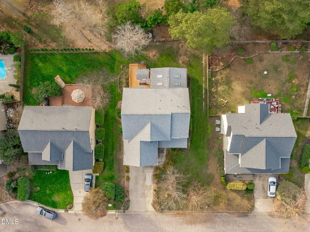 an aerial view of a house with a yard and a large tree