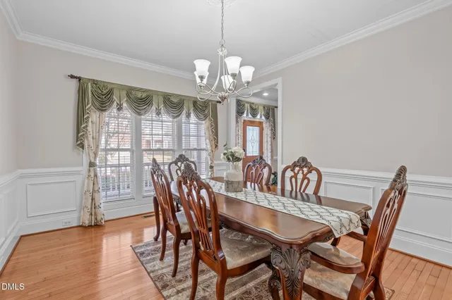 a view of a dining room with furniture a chandelier and wooden floor