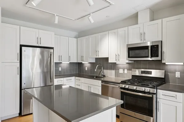 a kitchen with stainless steel appliances a stove a sink and a refrigerator