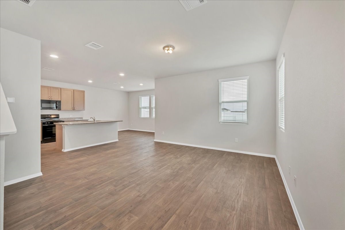116 Honeybee Lane Elgin, TX 78621 - Photo 11 of 37 a view of kitchen with wooden floor and windows