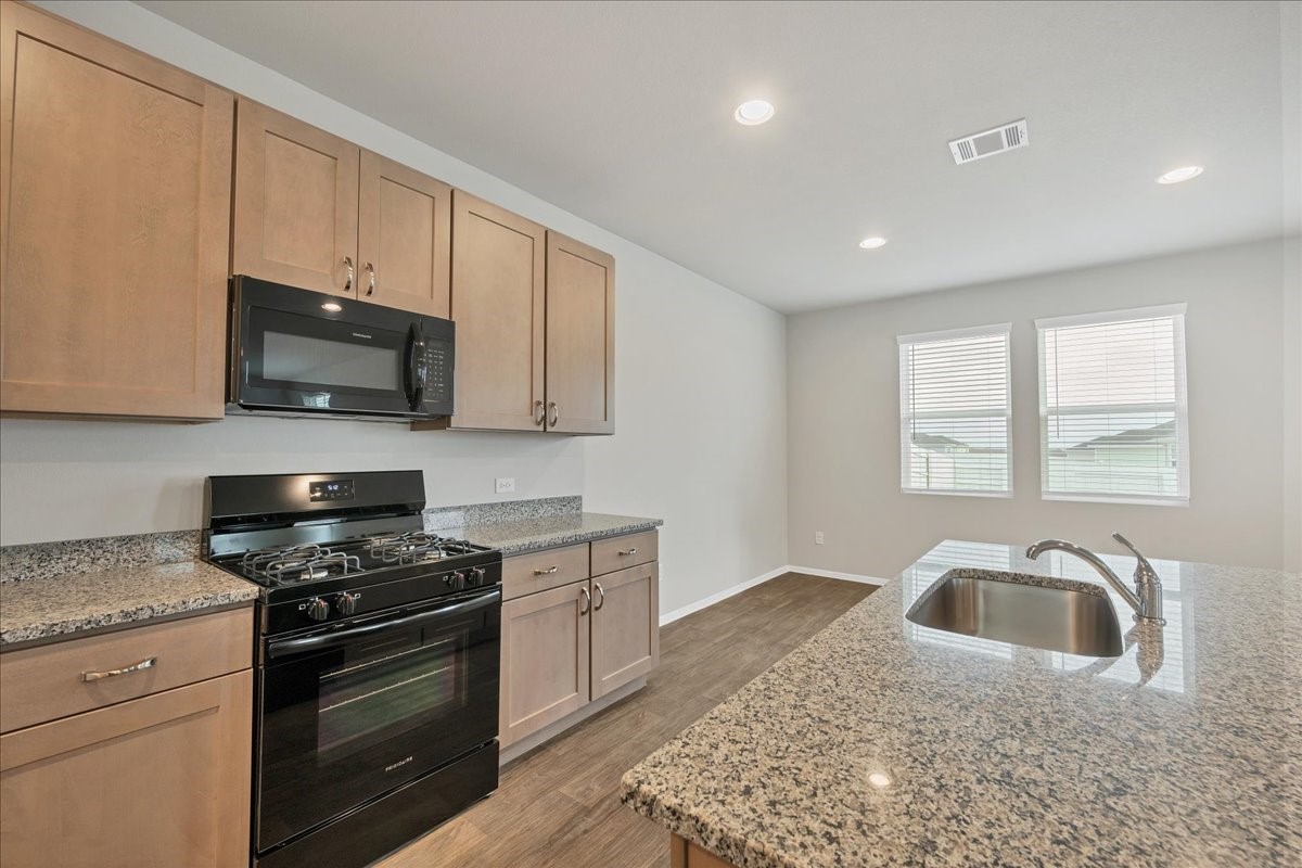 116 Honeybee Lane Elgin, TX 78621 - Photo 13 of 37 a kitchen with granite countertop white cabinets stainless steel appliances and a sink