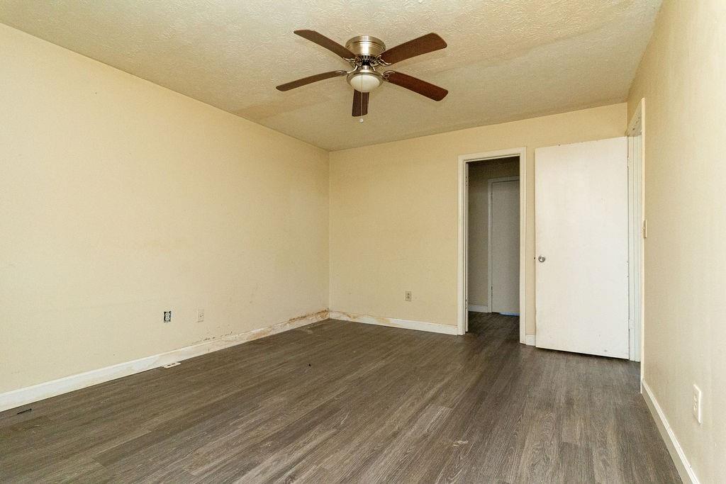 8654 Ashley Way Douglasville, GA 30134 - Photo 4 of 8 an empty room with wooden floor and a ceiling fan