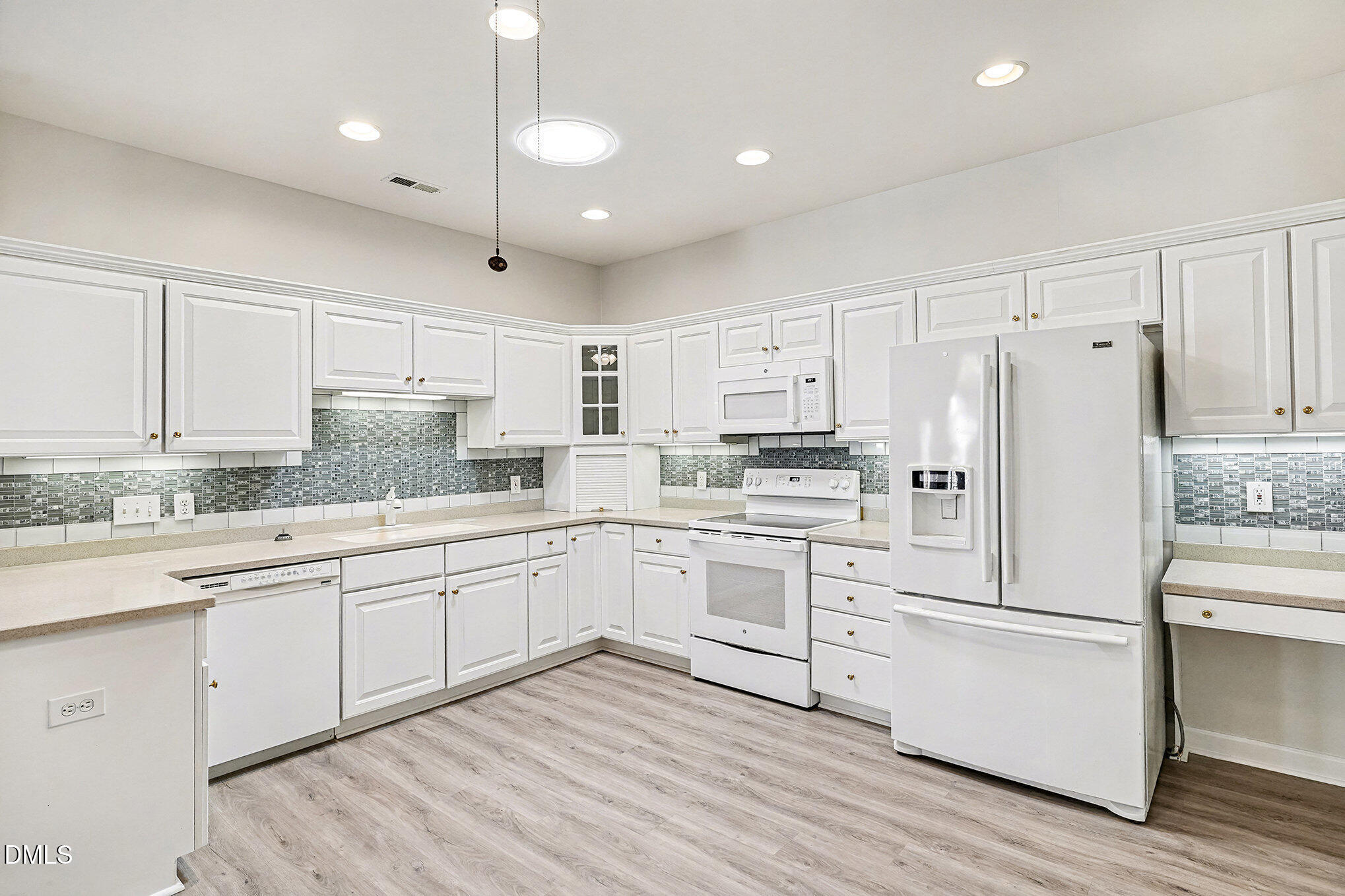 4703 Lewisham Court Raleigh, NC 27612 - Photo 11 of 27 a kitchen with granite countertop cabinets and white appliances