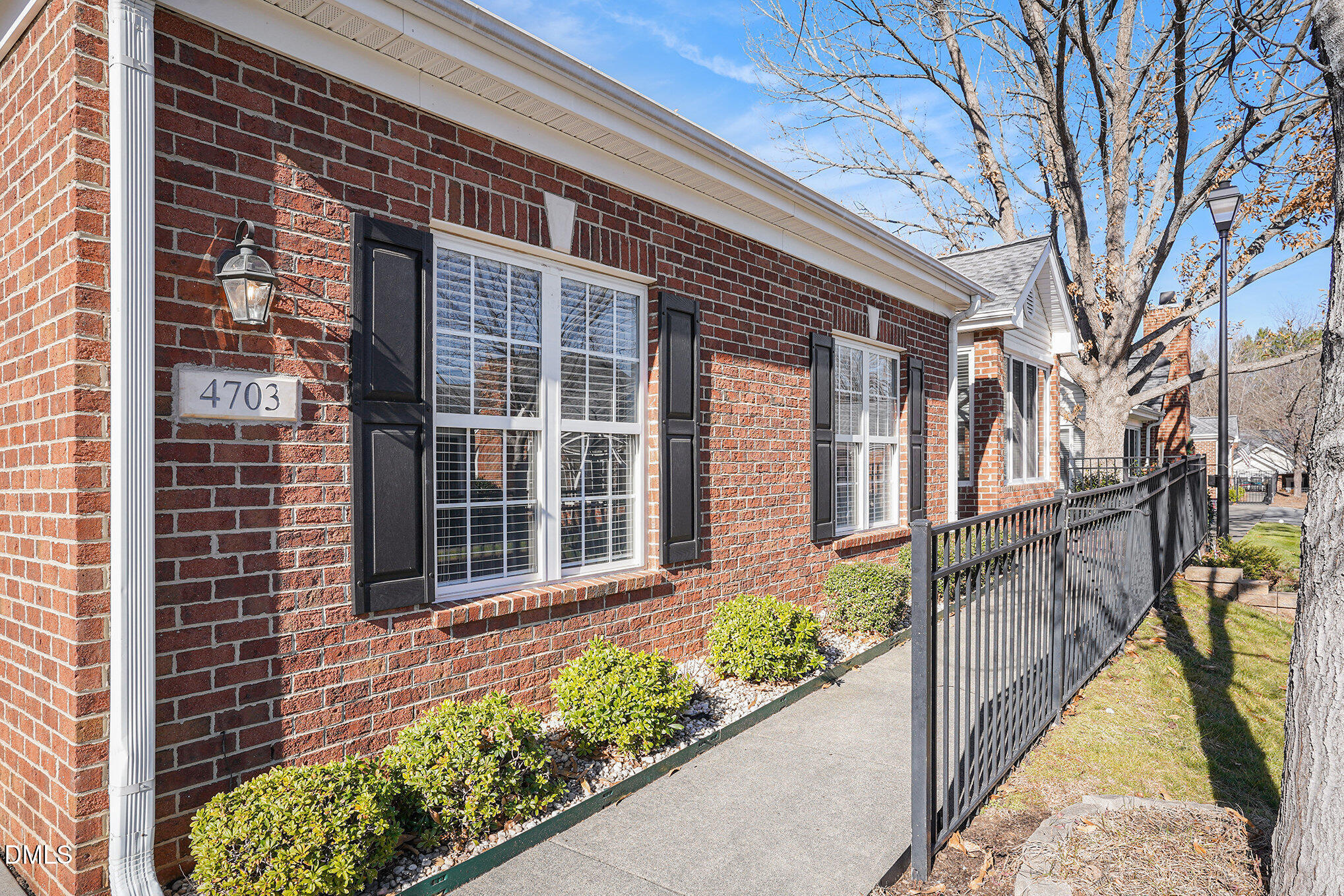 4703 Lewisham Court Raleigh, NC 27612 - Photo 24 of 27 a view of a brick house with large windows and a flower plants