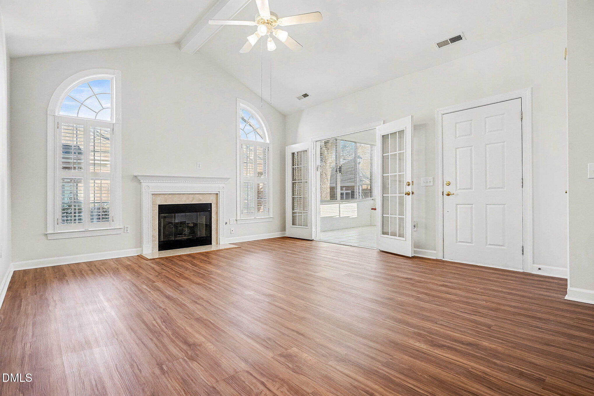 4703 Lewisham Court Raleigh, NC 27612 - Photo 6 of 27 a view of an empty room with wooden floor fireplace and a window