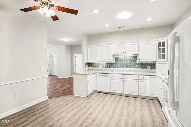 a large white kitchen with stainless steel appliances