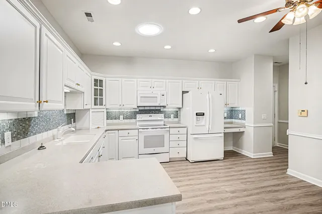 a kitchen with granite countertop cabinets and white appliances