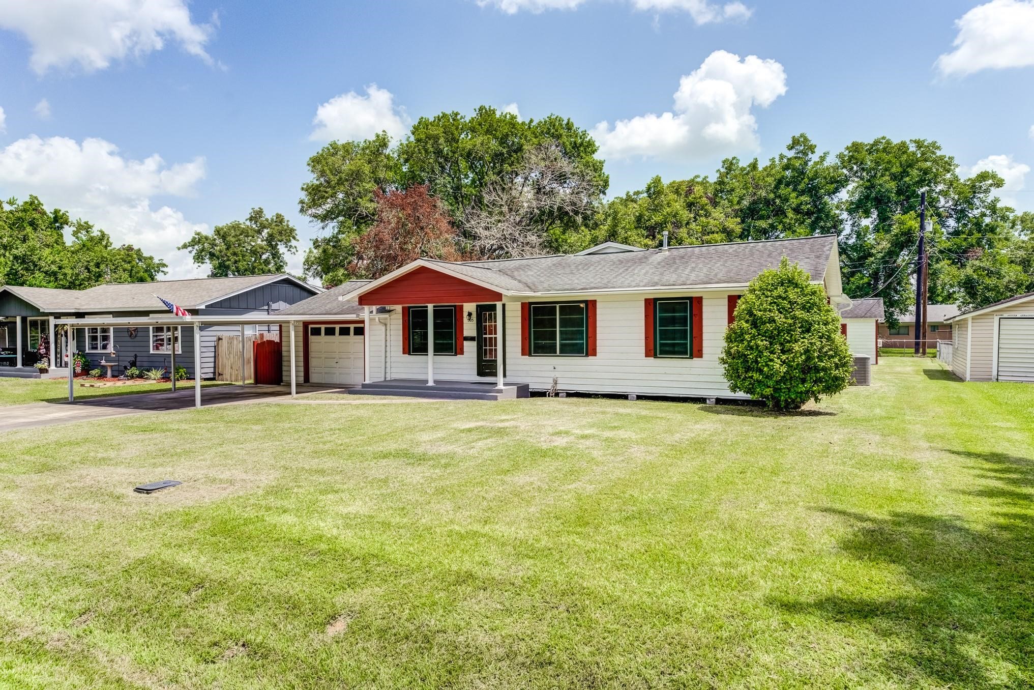 305 Yaupon Street Sweeny, TX 77480 - Photo 13 of 22 Charming single-story home with a welcoming front porch and attached garage, set on a spacious, well-maintained lawn. The exterior features a classic design with red accents and surrounding greenery, perfect for comfortable suburban living.