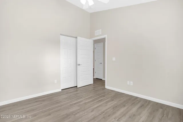 a view of an empty room with wooden floor