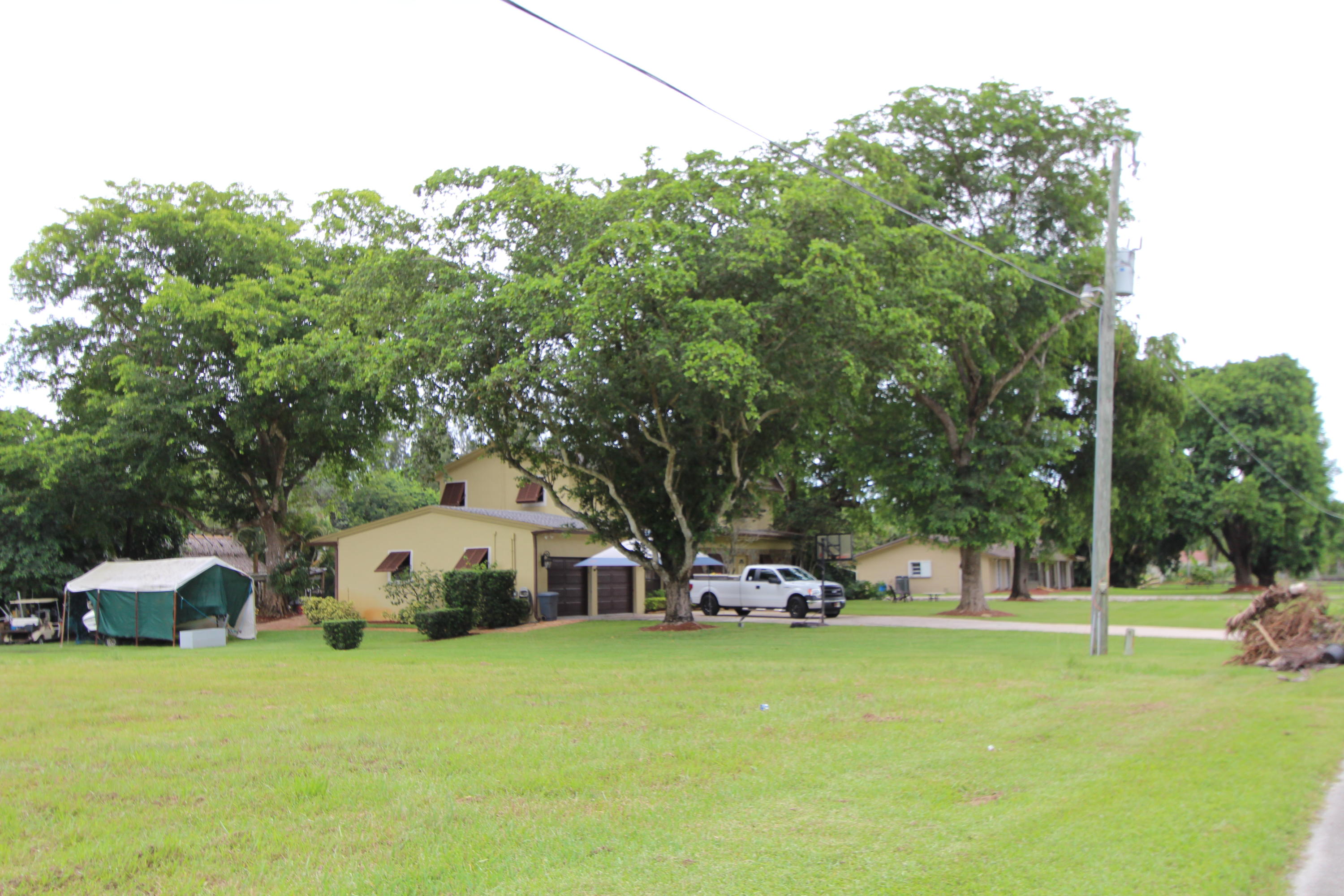 0 Southwest 195th Terrace Southwest Ranches, FL 33332 - Photo 3 of 7 a front view of a house with a garden and trees