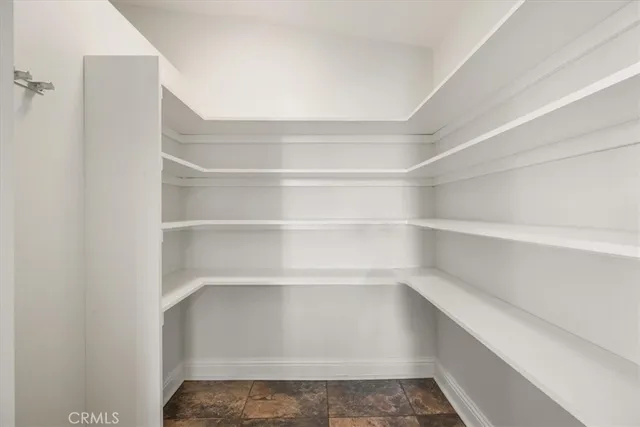 a large living room with stainless steel appliances furniture a rug and a large window