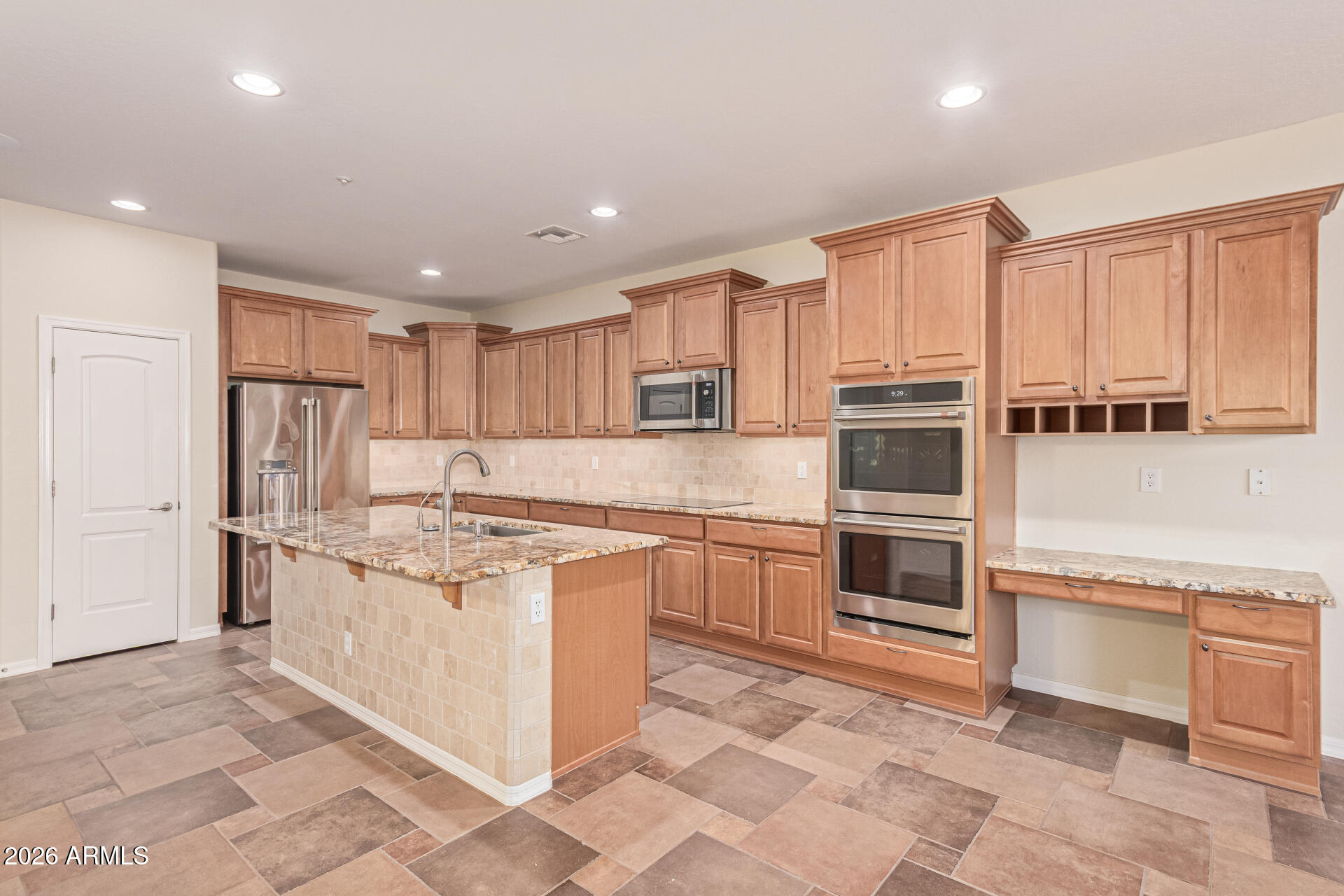9058 West Redbird Road Peoria, AZ 85383 - Photo 12 of 39 a kitchen with stainless steel appliances granite countertop a stove a sink and a refrigerator