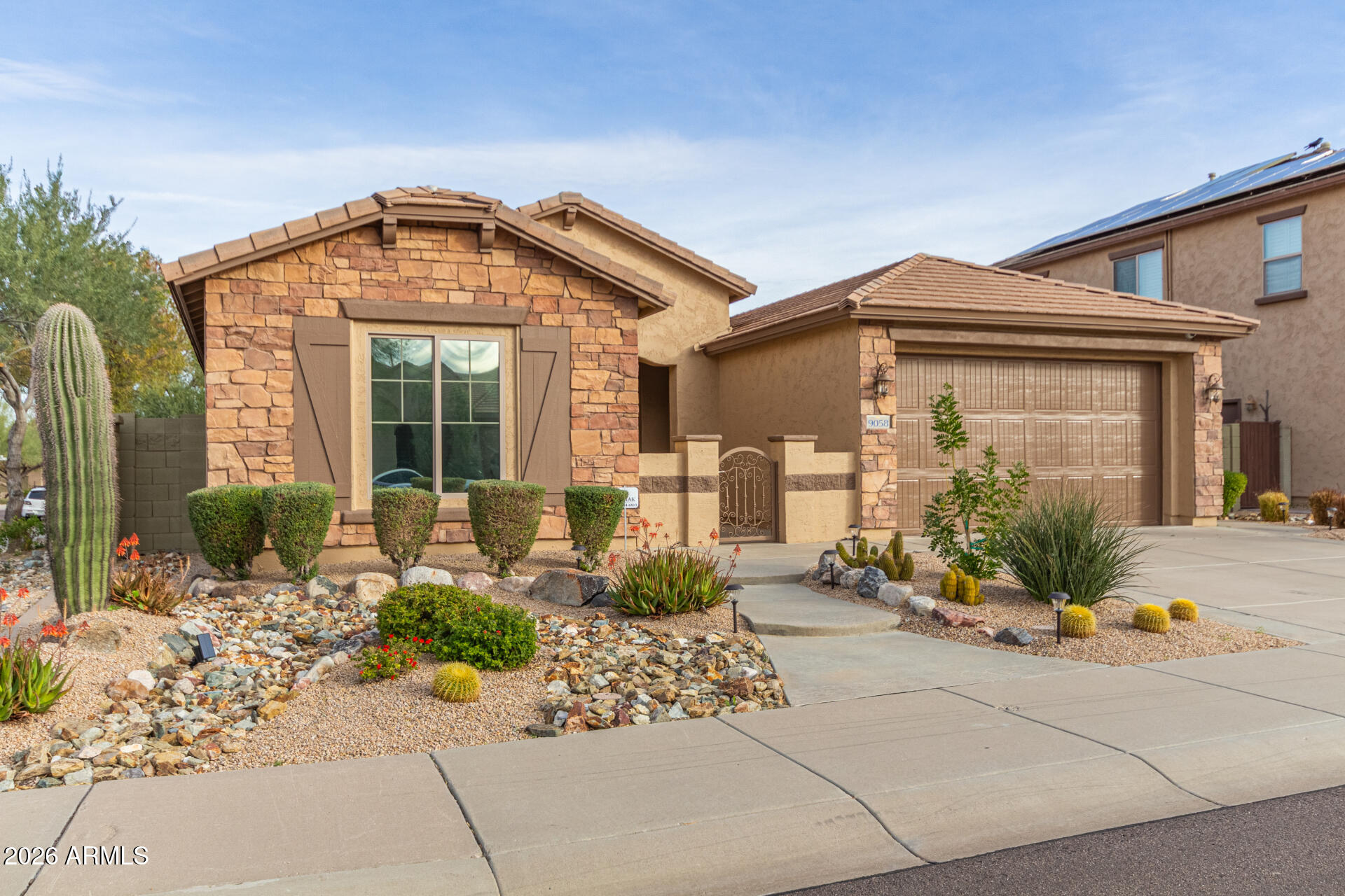 9058 West Redbird Road Peoria, AZ 85383 - Photo 2 of 39 a front view of a house with a garden