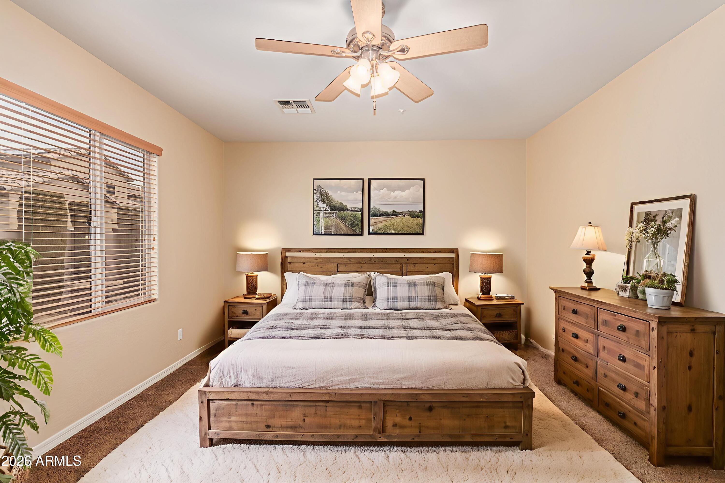 9058 West Redbird Road Peoria, AZ 85383 - Photo 4 of 39 a bedroom with a bed a dresser and next to a window