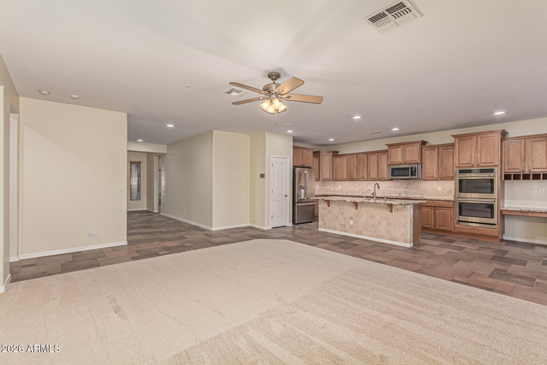 9058 West Redbird Road Peoria, AZ 85383 - Photo 9 of 39 a large white kitchen with kitchen island a stove a sink dishwasher and a refrigerator with wooden floor