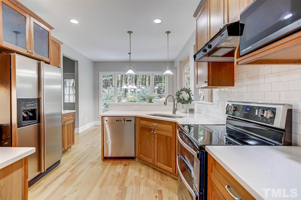 10424 Roadstead Way West Raleigh, NC 27613 - Photo 13 of 29 a kitchen with stainless steel appliances granite countertop a sink a stove and a refrigerator