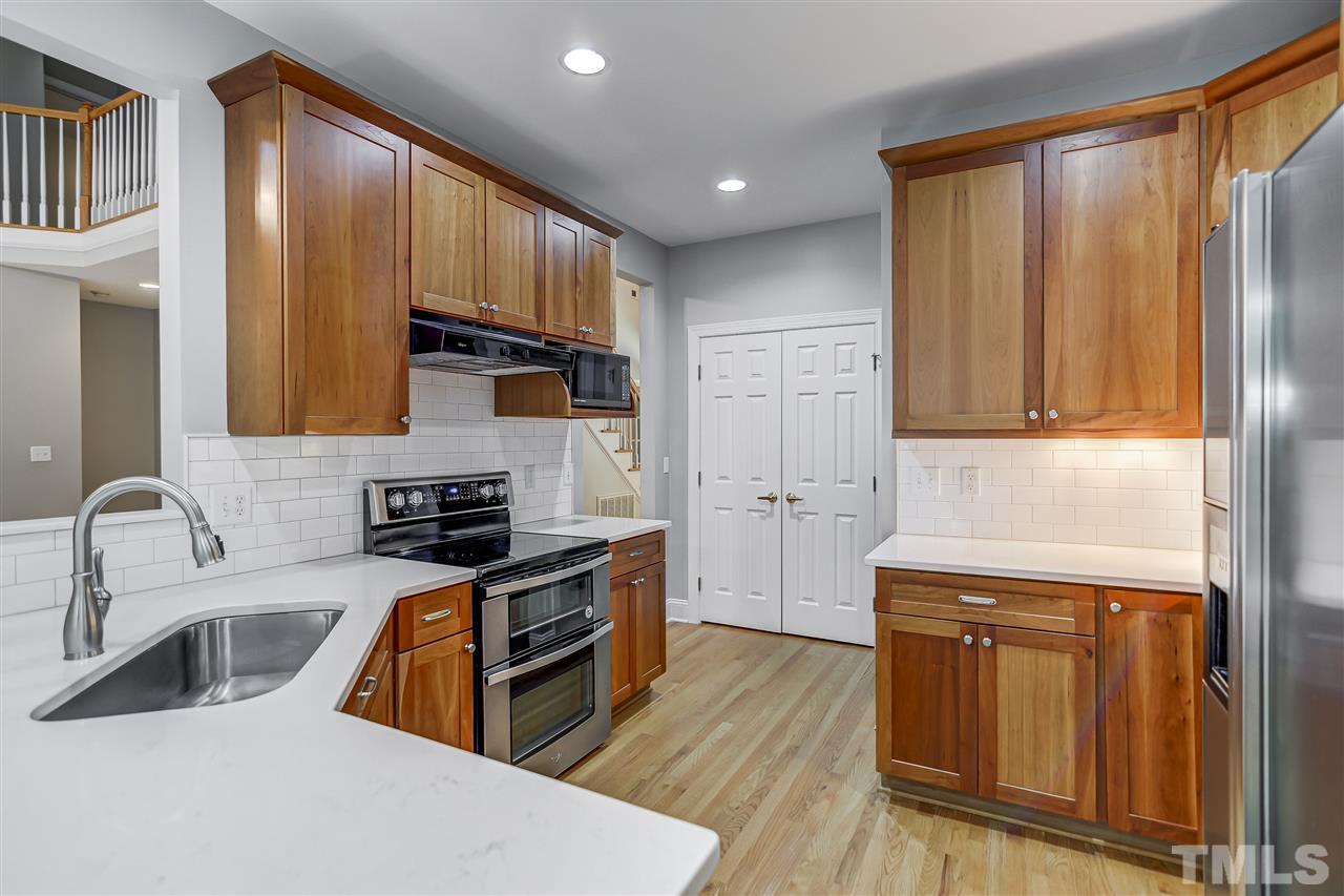 10424 Roadstead Way West Raleigh, NC 27613 - Photo 14 of 29 a kitchen with stainless steel appliances granite countertop a refrigerator a sink dishwasher stove and wooden cabinets with wooden floor