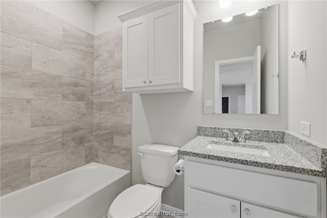 1922 Viva Road Bryan, TX 77807 - Photo 29 of 45 Upstairs full bath featuring granite countertops, painted cabinetry, and a tub/shower combination.