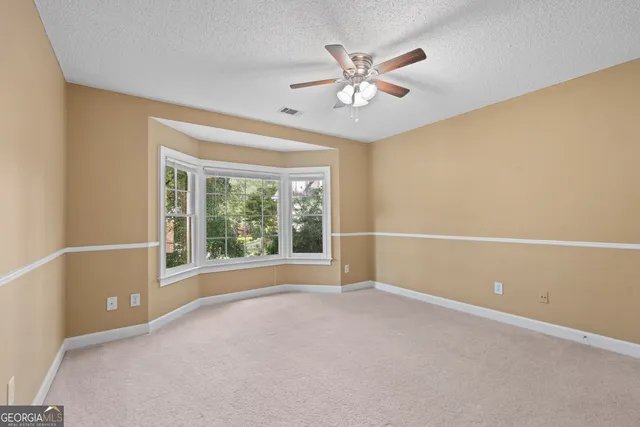 a bathroom with a toilet a double vanity sink and a mirror