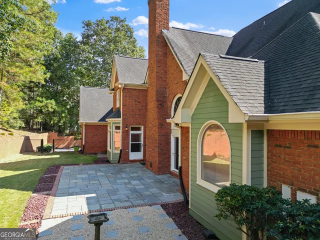 a view of a house with a yard and a forest