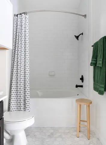 a bathroom with a shower a toilet and a sink