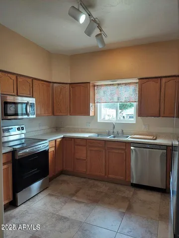 a kitchen with stainless steel appliances granite countertop a sink counter space cabinets and a large window