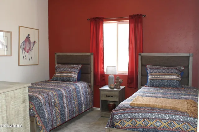 a bedroom with a bed and a painting on the wall