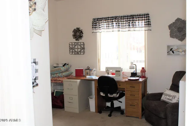 a view of a workspace with furniture and a window