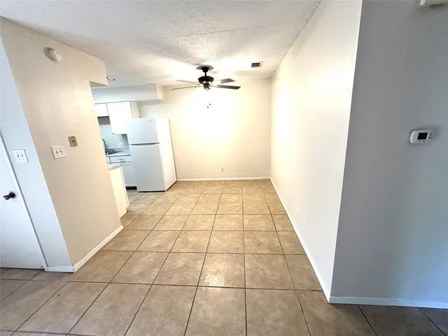 a view of a kitchen with refrigerator and white cabinets