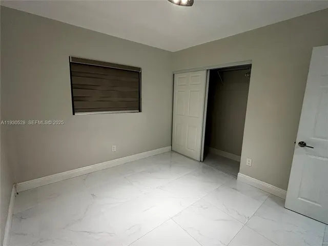 an empty room with cabinet and mirrors