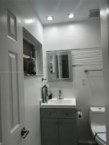 a white toilet sitting next to a bathroom sink
