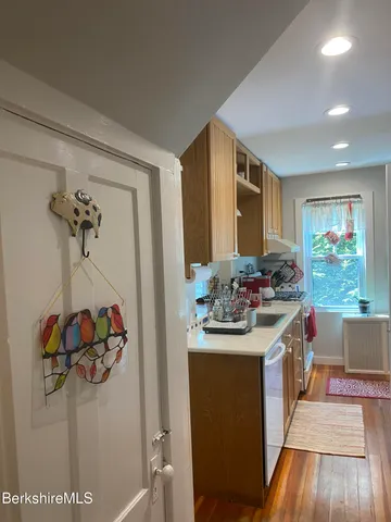 a kitchen with a sink and wooden floor