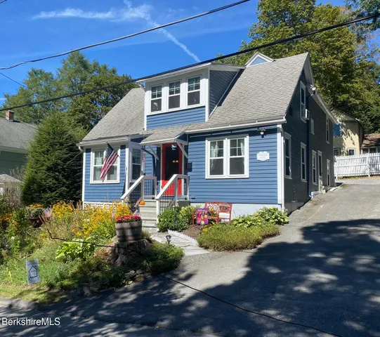 a front view of a house with a yard and potted plants