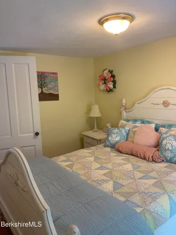 a bedroom with a bed and a painting on the wall