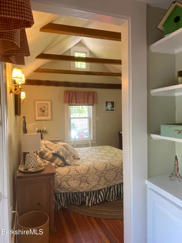 a bedroom with a bed and dresser with mirror