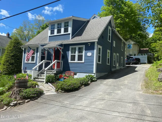 a view of a brick house with a large windows and flower plants