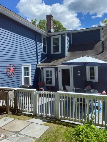 a front view of a house with a yard and potted plants