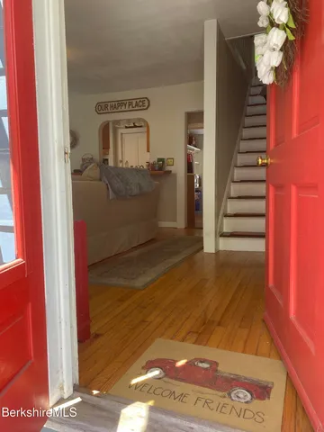 a view of a hallway with entryway wooden floor and front door