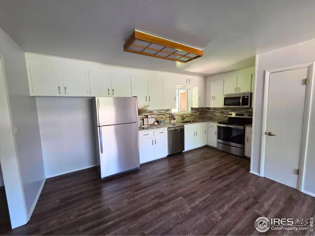 a kitchen with wooden floors and white appliances