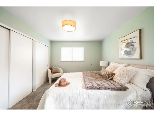 a bedroom with a bed and a painting on the wall