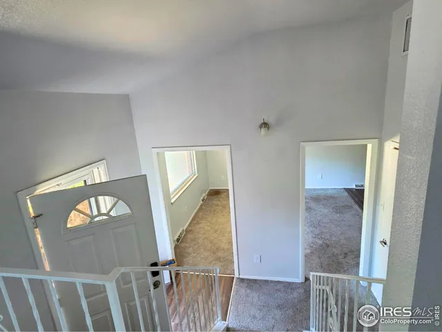 an empty room with windows and fireplace