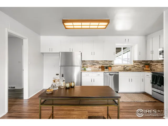 a kitchen with a refrigerator and a stove top oven