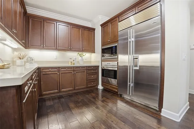 a kitchen with a sink refrigerator and cabinets