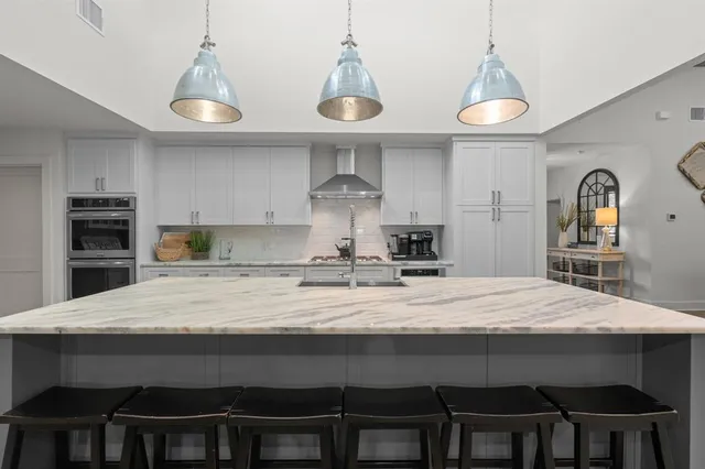 a large kitchen with stainless steel appliances lots of counter space and wooden floor