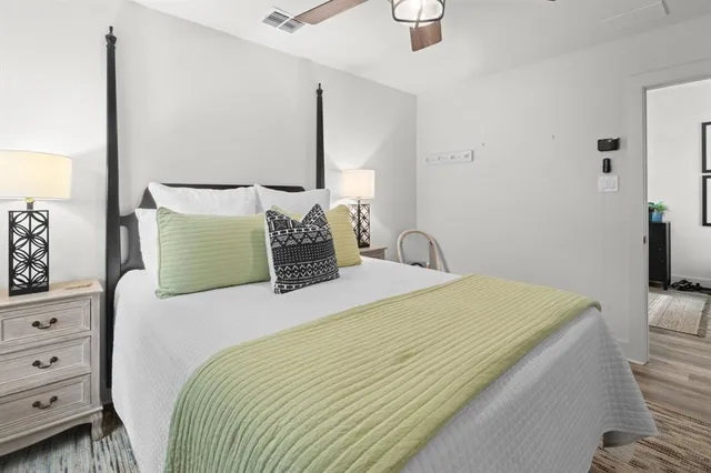 a bedroom with a large bed and a chandelier