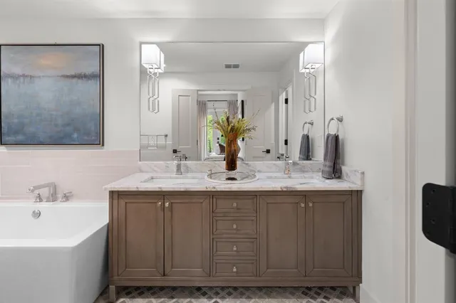 a bathroom with a granite countertop sink a mirror and a shower