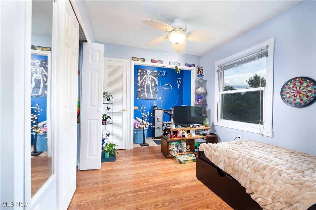 Bedroom with ceiling fan and light hardwood / wood-style floors