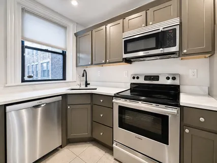 a kitchen with stainless steel appliances granite countertop a stove microwave and sink