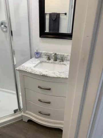 a bathroom with a granite countertop sink and a mirror