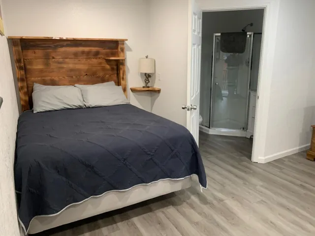 a bedroom with a bed and wooden floor